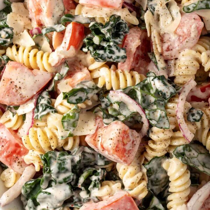 A white bowl filled with Kale Pasta Salad.
