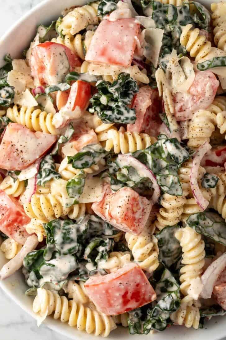 A white bowl filled with Mediterranean Pasta Salad.