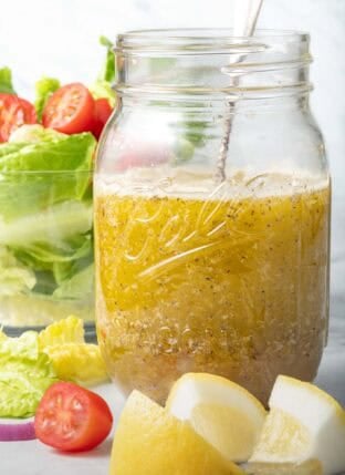 A clear mason jar filled with Mediterranean Salad Dressing.