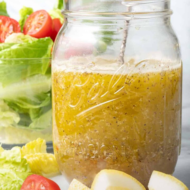 A clear mason jar filled with Mediterranean Salad Dressing.