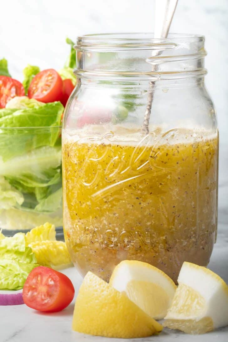 A clear mason jar filled with Mediterranean Salad Dressing.