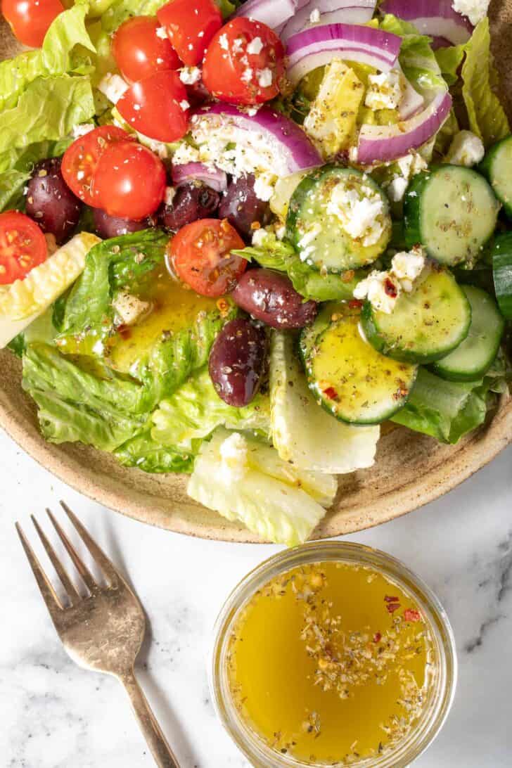 A bowl of salad tossed with Mediterranean Salad Dressing.