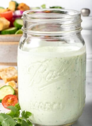 A clear mason jar filled with Mexican Caesar Salad Dressing.