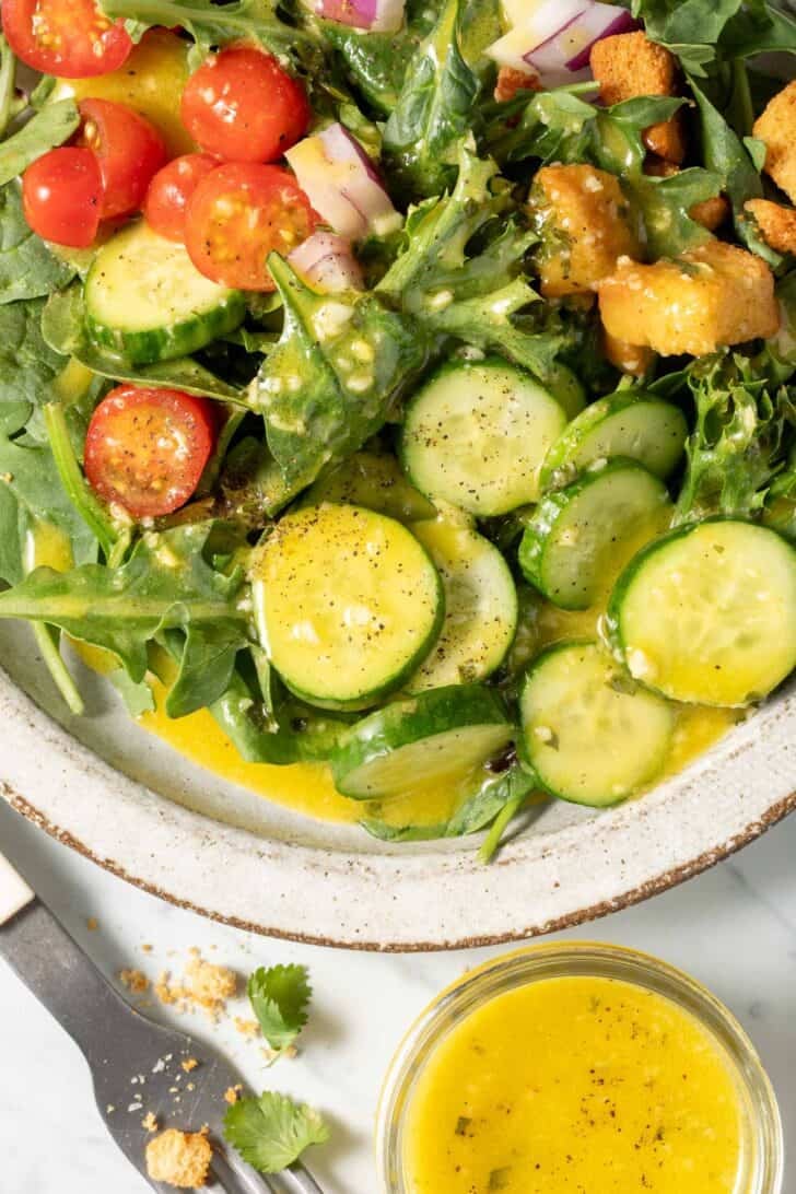 A plate filled with salad tossed with Orange Vinaigrette.
