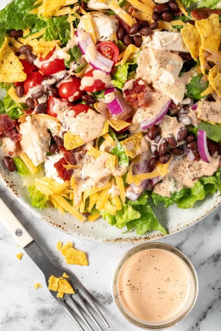 A white bowl filled with a green salad topped with Southwest Salad Dressing.