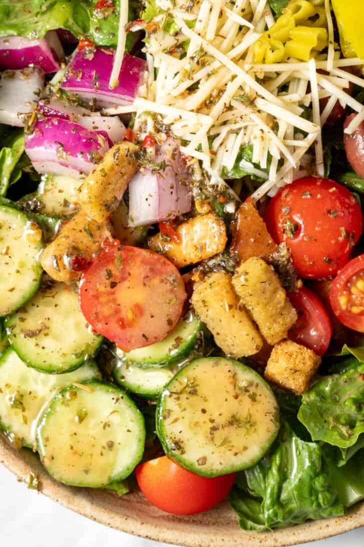 A bowl filled with salad tossed with Zesty Italian Salad Dressing.