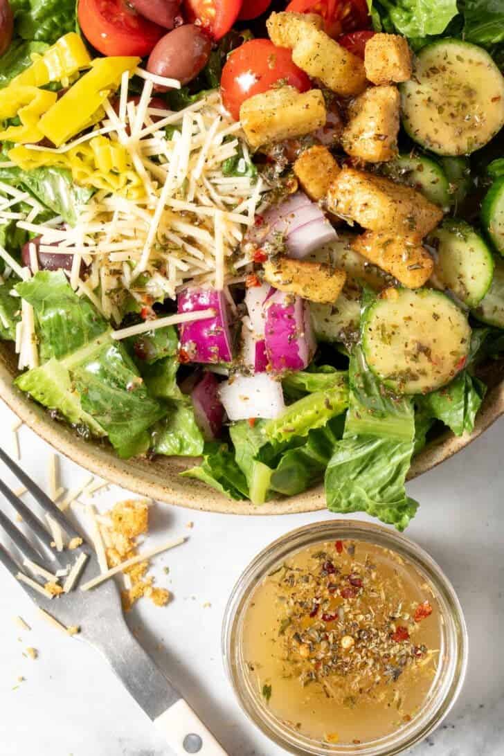 A bowl filled with salad tossed with Zesty Italian Dressing.