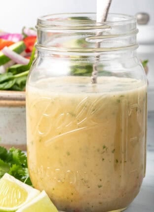 A clear mason jar filled with Asian Salad Dressing.