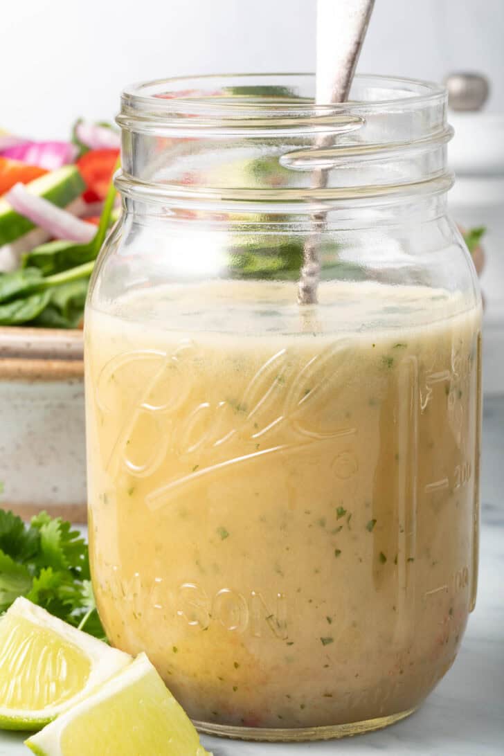 A clear mason jar filled with Asian Salad Dressing.