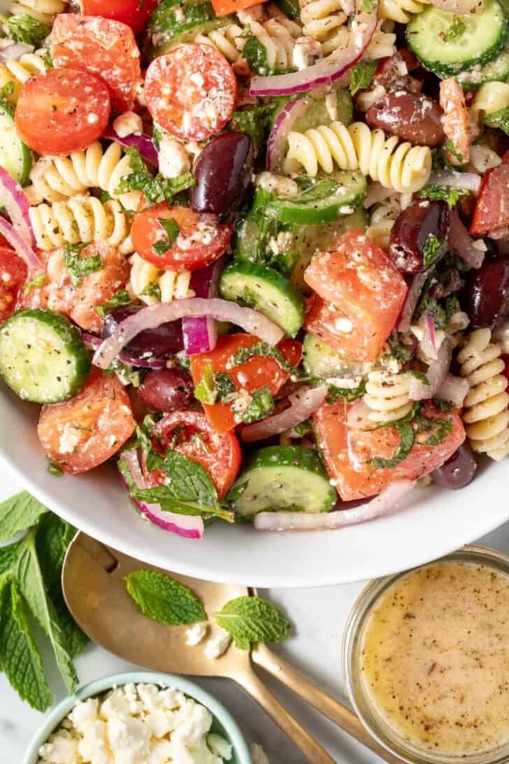 A white bowl filled with Greek Pasta Salad.
