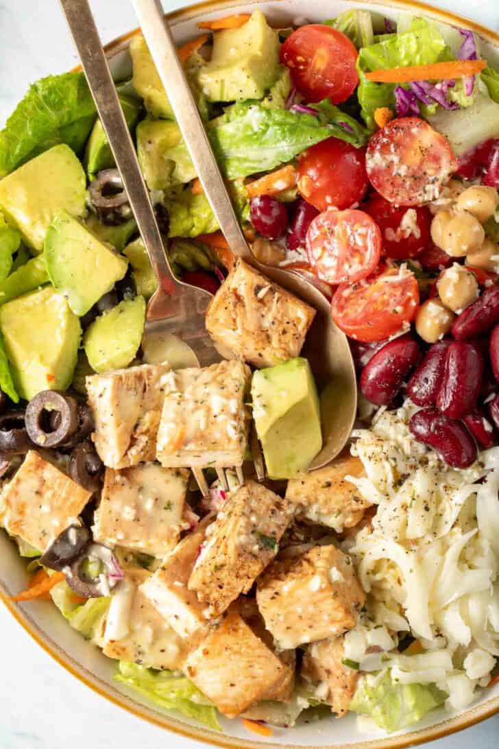 Chop Salad in a bowl with serving spoons.