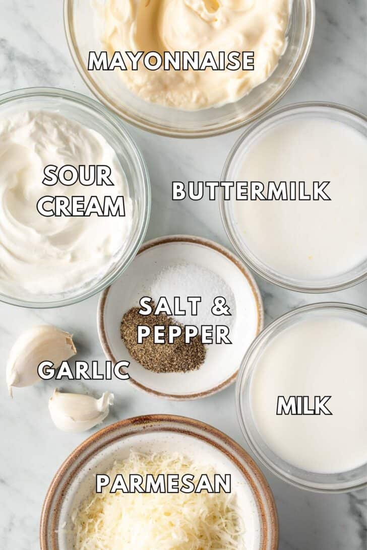 Clear glass bowls filled with buttermilk, milk, Parmesan cheese, and mayonnaise.
