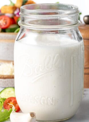 A clear mason jar filled with homemade Creamy Garlic Dressing.