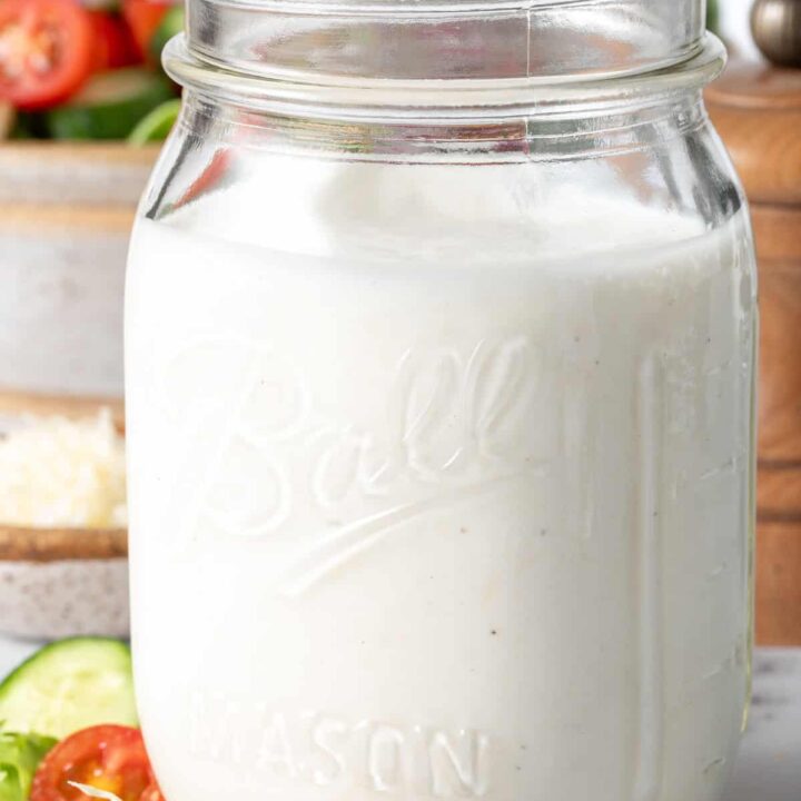A clear mason jar filled with homemade Creamy Garlic Dressing.