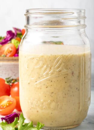 A clear mason jar filled with the best Creamy Vinaigrette.