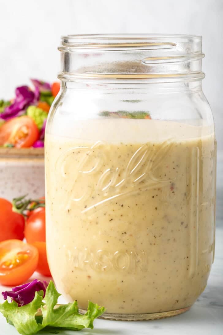 A clear mason jar filled with a Creamy Vinaigrette.