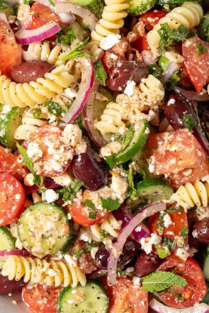 A white bowl filled with the best Greek pasta salad.