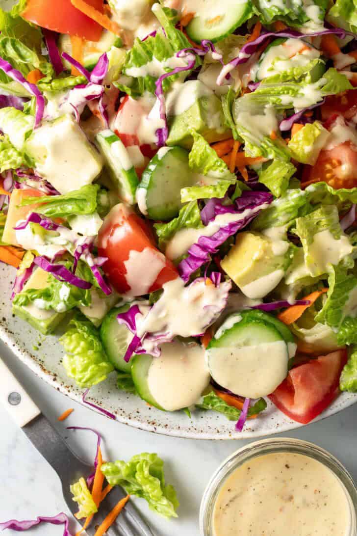 A white plate filled with a fresh Garden Salad.