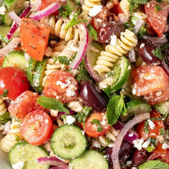 A white bowl filled with Greek Pasta Salad.