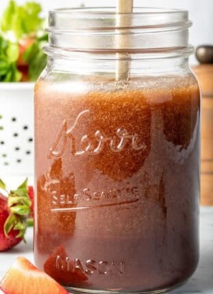 A clear mason jar filled with Pomegranate Vinaigrette.