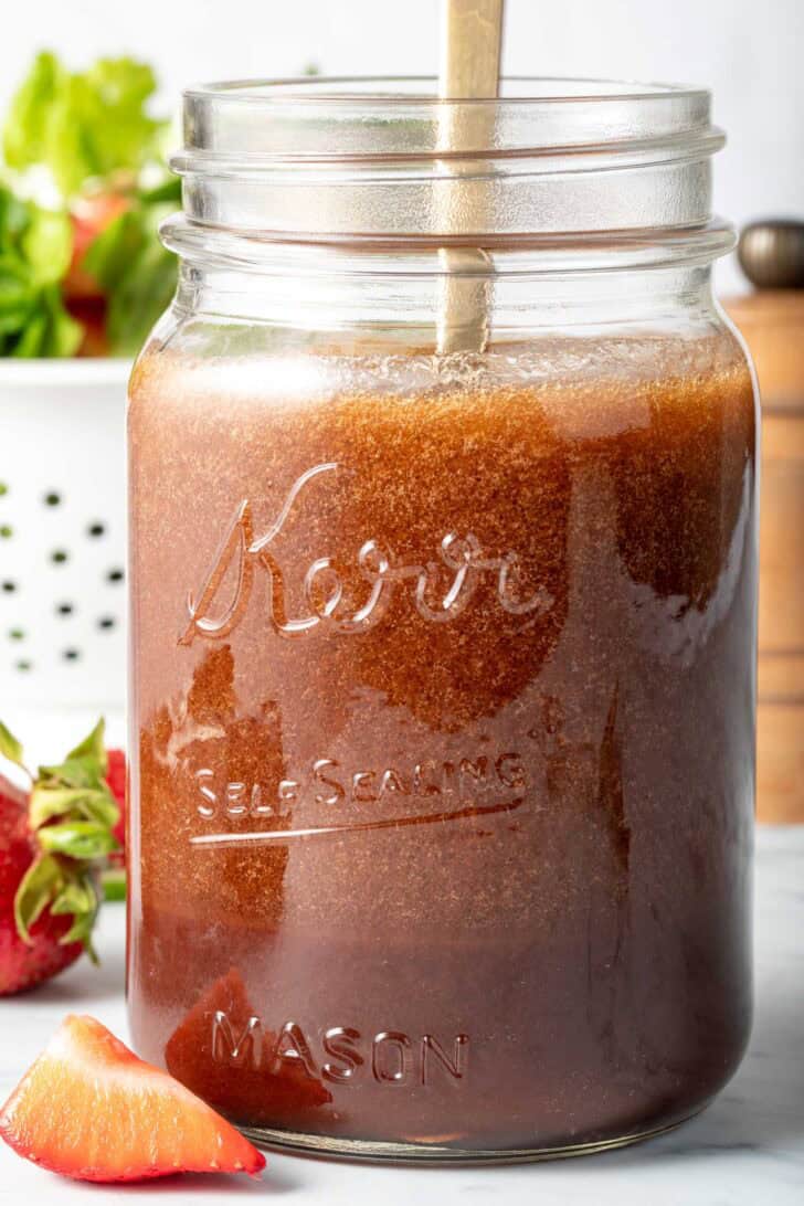 A clear mason jar filled with Pomegranate Vinaigrette.
