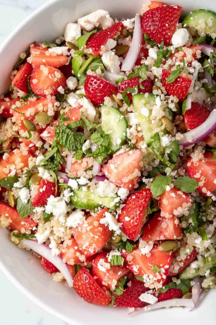 A white bowl filled with Quinoa Salad with Strawberries.
