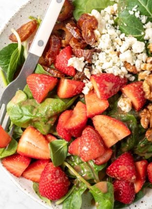 A white plate filled with Strawberry Spinach Salad.