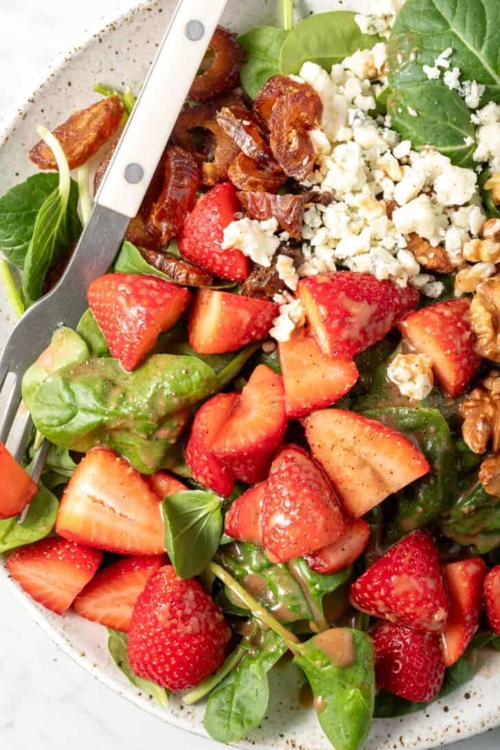 A white plate filled with Strawberry Spinach Salad.