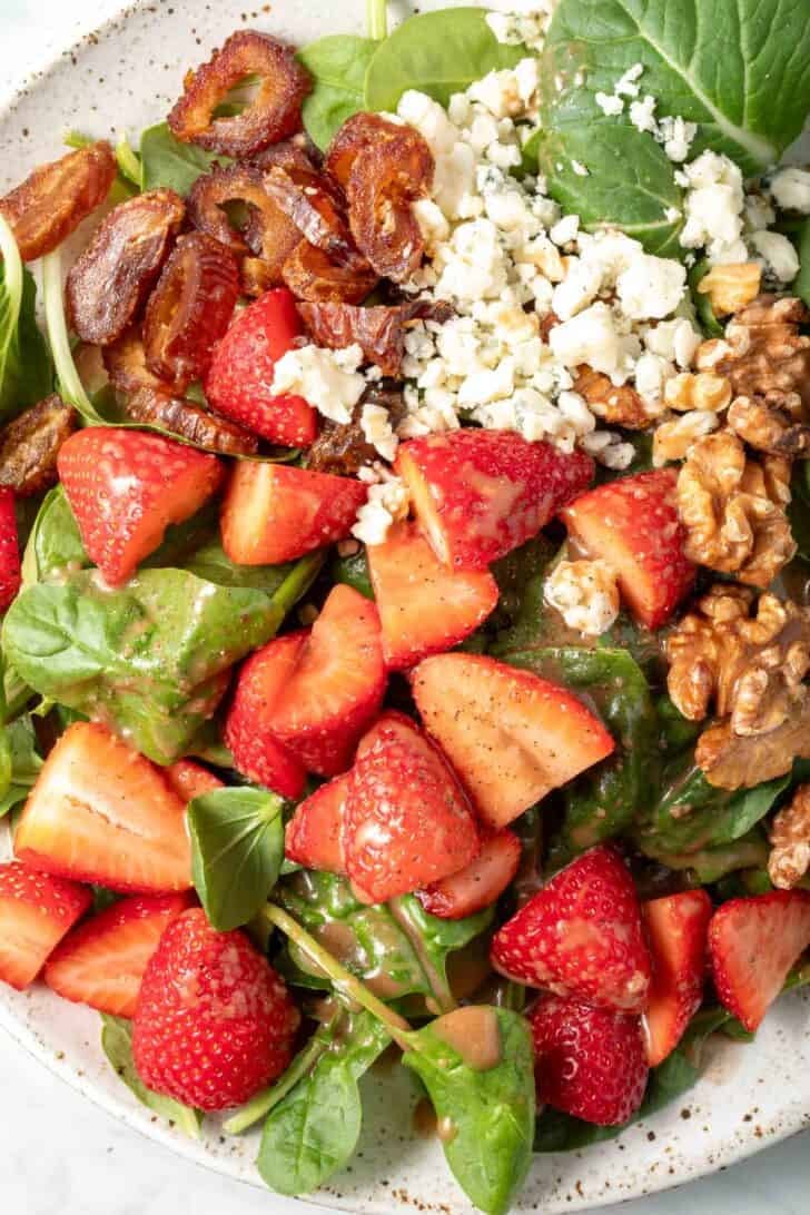 A white plate filled with Strawberry Spinach Salad.