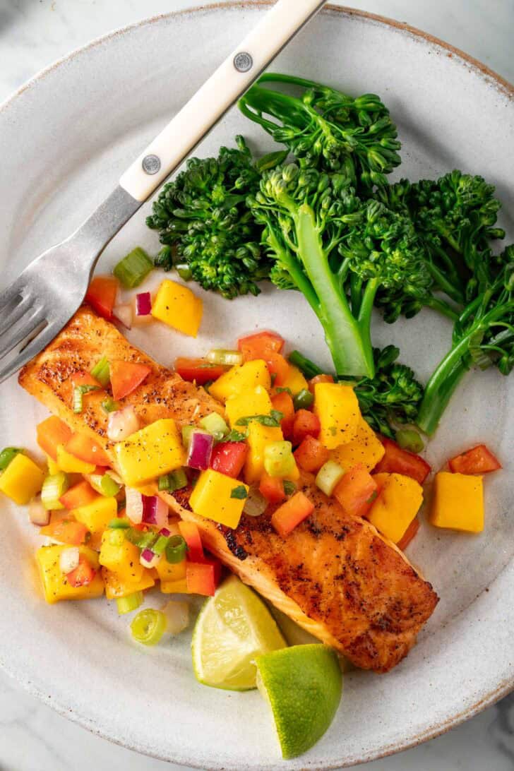 Broiled salmon with mango salsa on a plate.