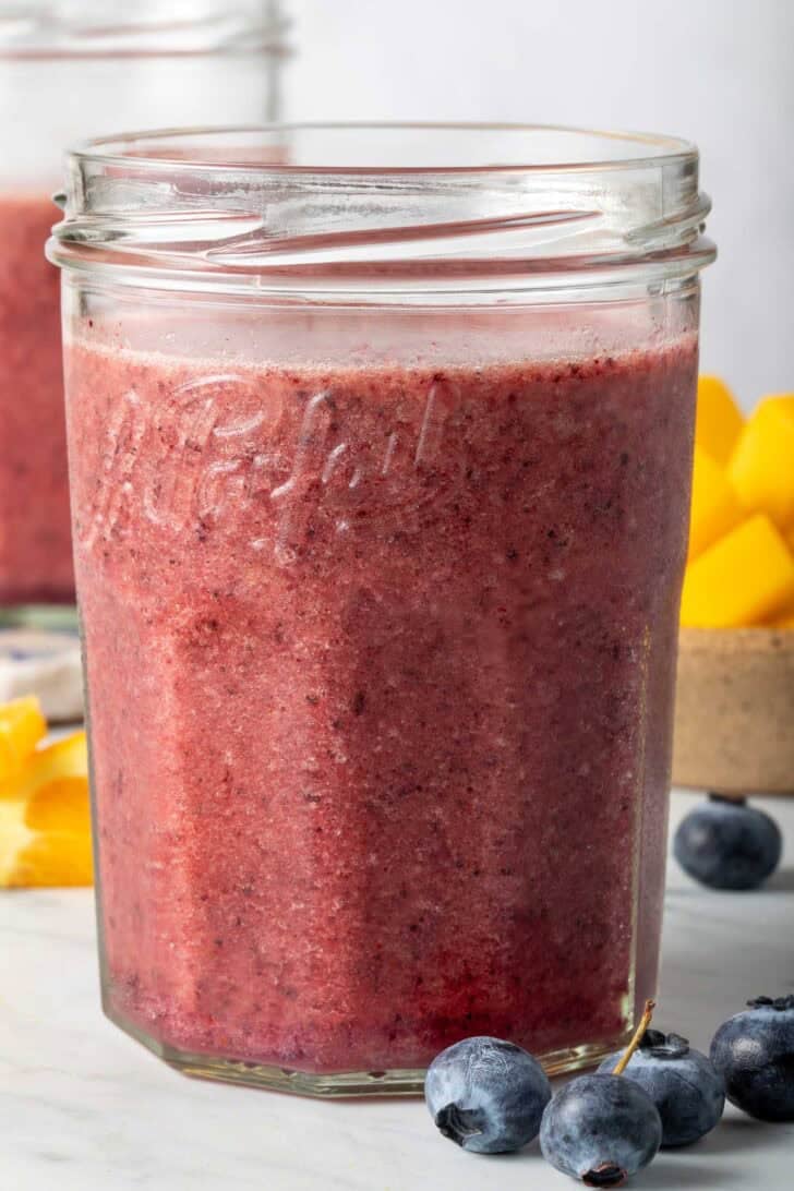 Blueberry and Mango Smoothie in a clear drinking glass.
