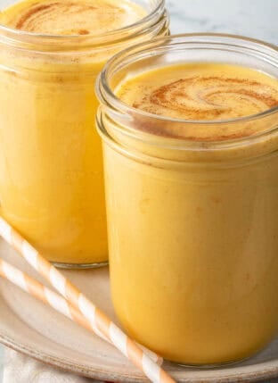 A Mango Lassi Drink in a clear glass mason jar.