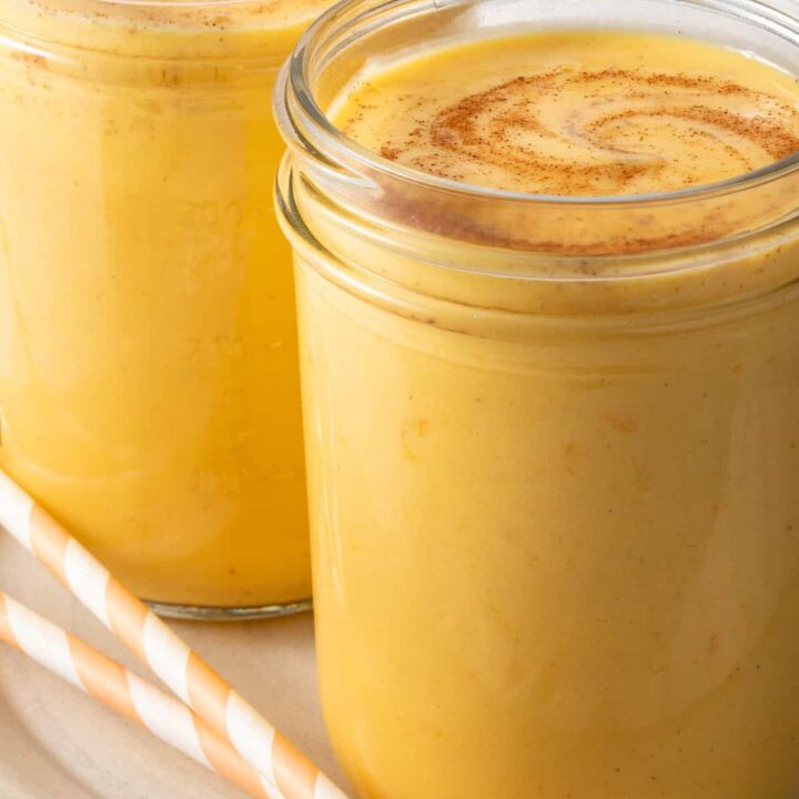 A Mango Lassi Drink in a clear glass mason jar.