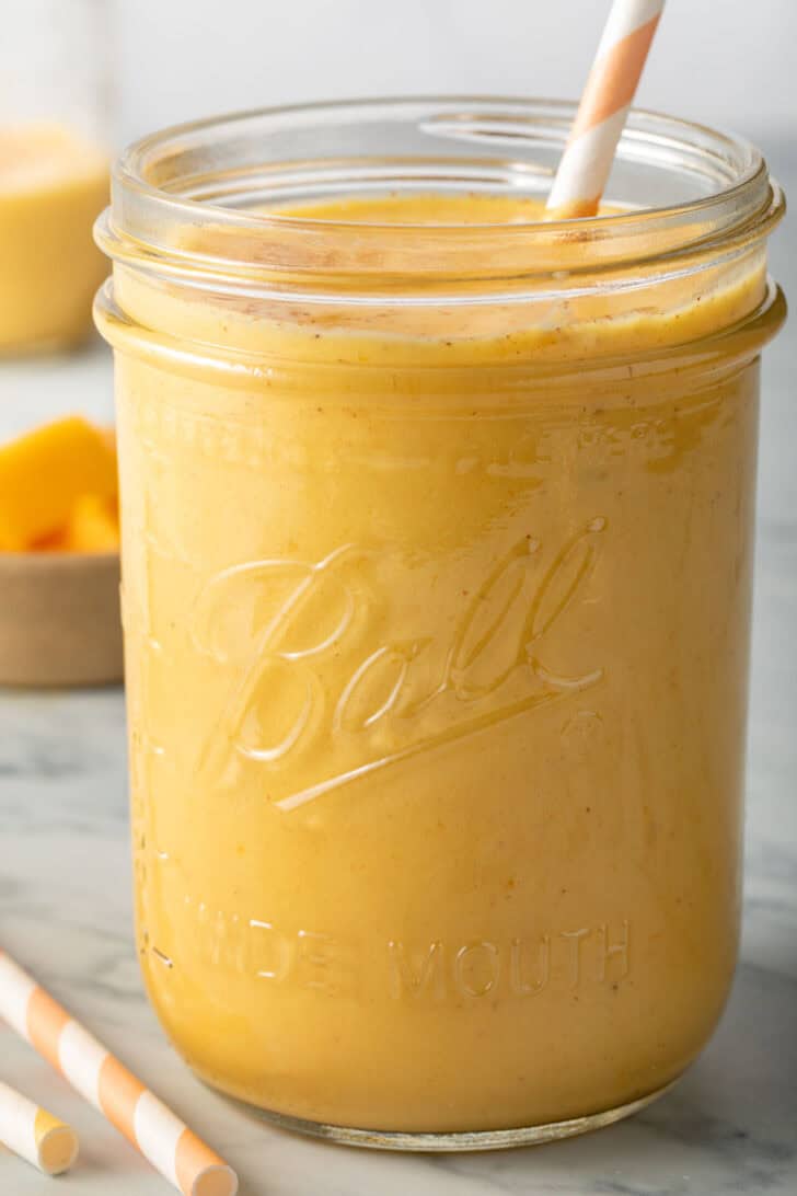Mango Lassi Drink in a clear glass mason jar.