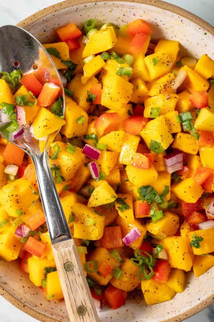 Best Mango Salsa in a bowl with a spoon.