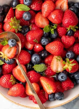Mixed Berry Salad in a bowl with a spoon in it.