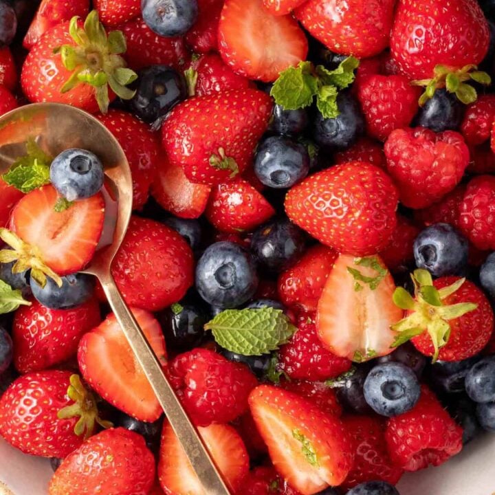 Mixed Berry Salad in a bowl with a spoon in it.