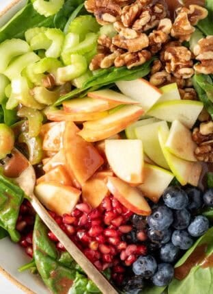 Apple Spinach Salad with walnuts in a bowl.