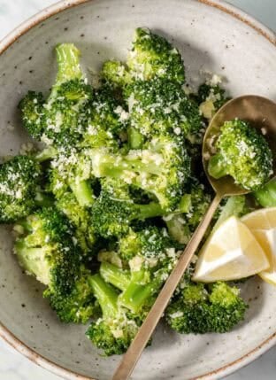 Steamed Broccoli in a bowl with a spoon.