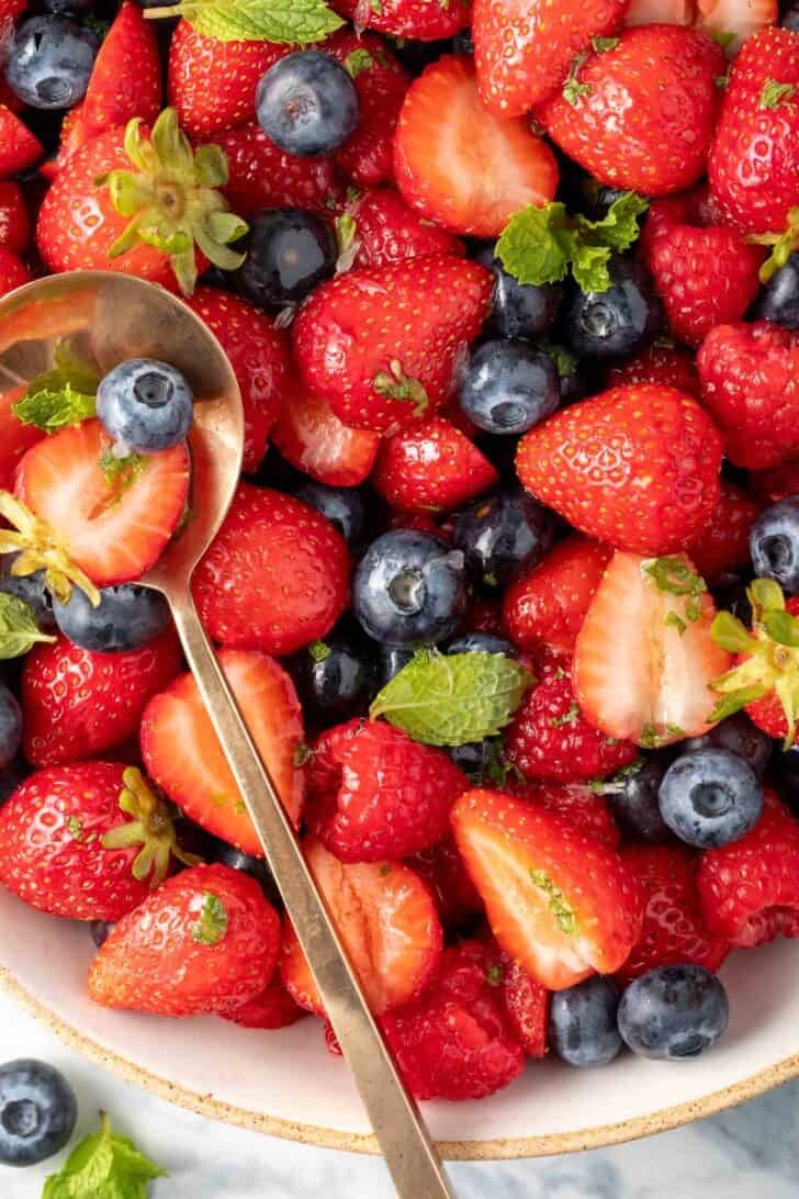 Berry Salad in a bowl with a spoon in it.