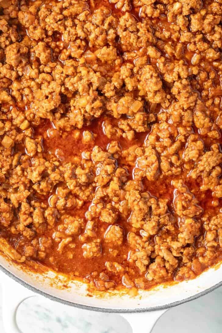 Seasoned ground turkey for tacos in a white skillet.
