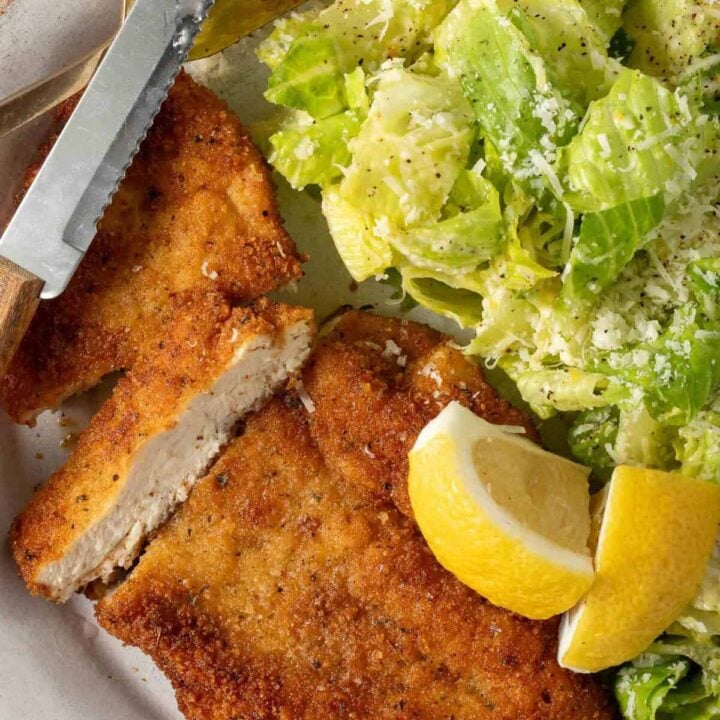 Chicken Milanese with salad on a plate.