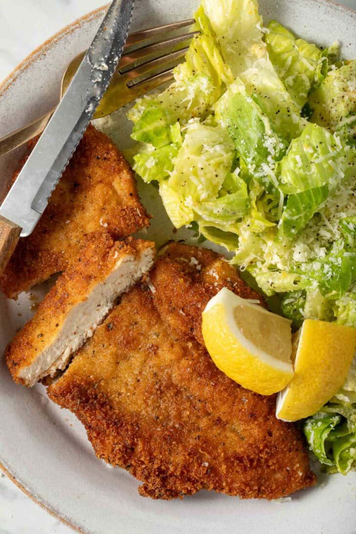 Chicken MIlanese with salad on a plate.