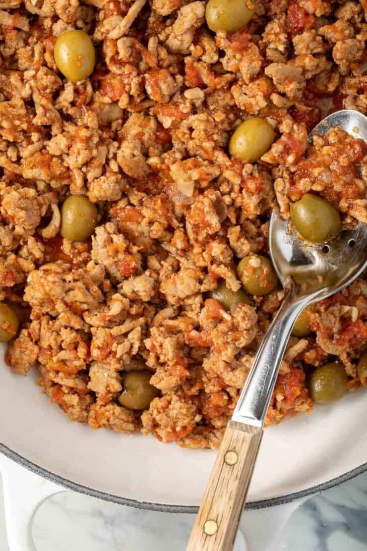 A white skillet filled with Cuban Picadillo.