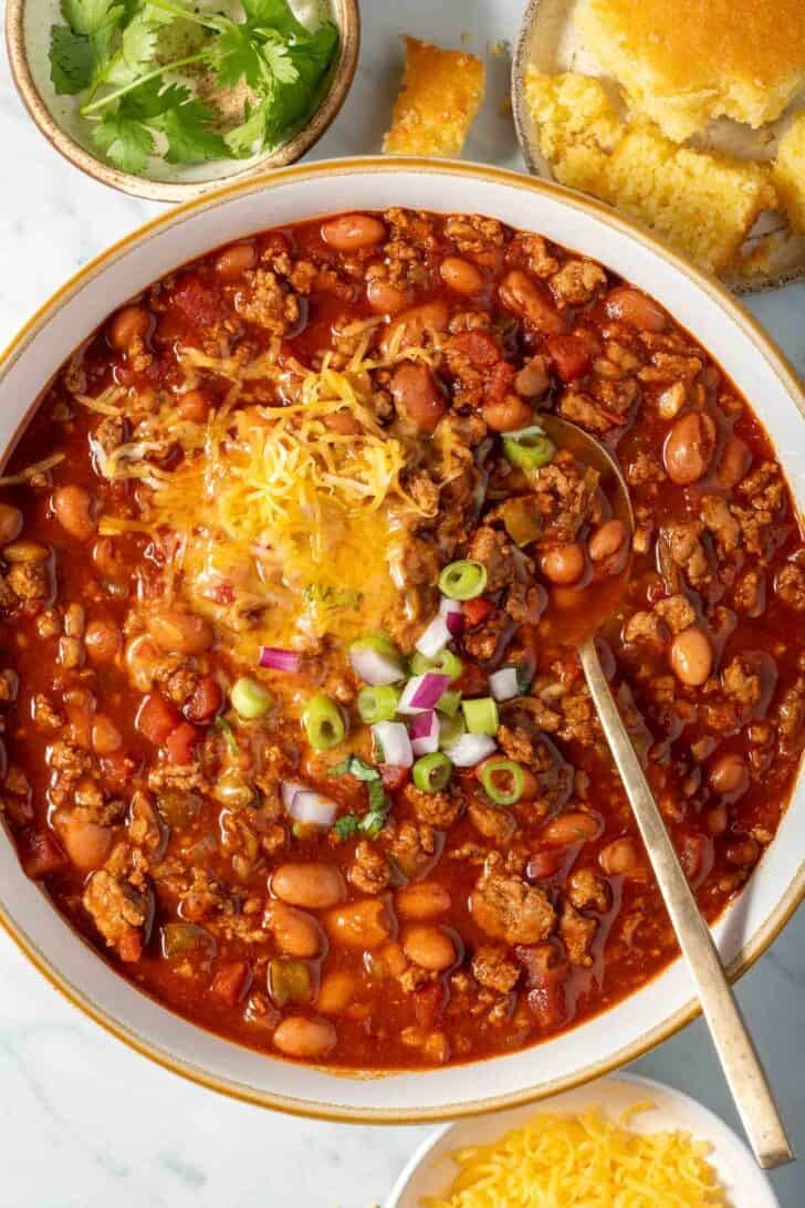 Ground Turkey Chili in a white bowl with a spoon.