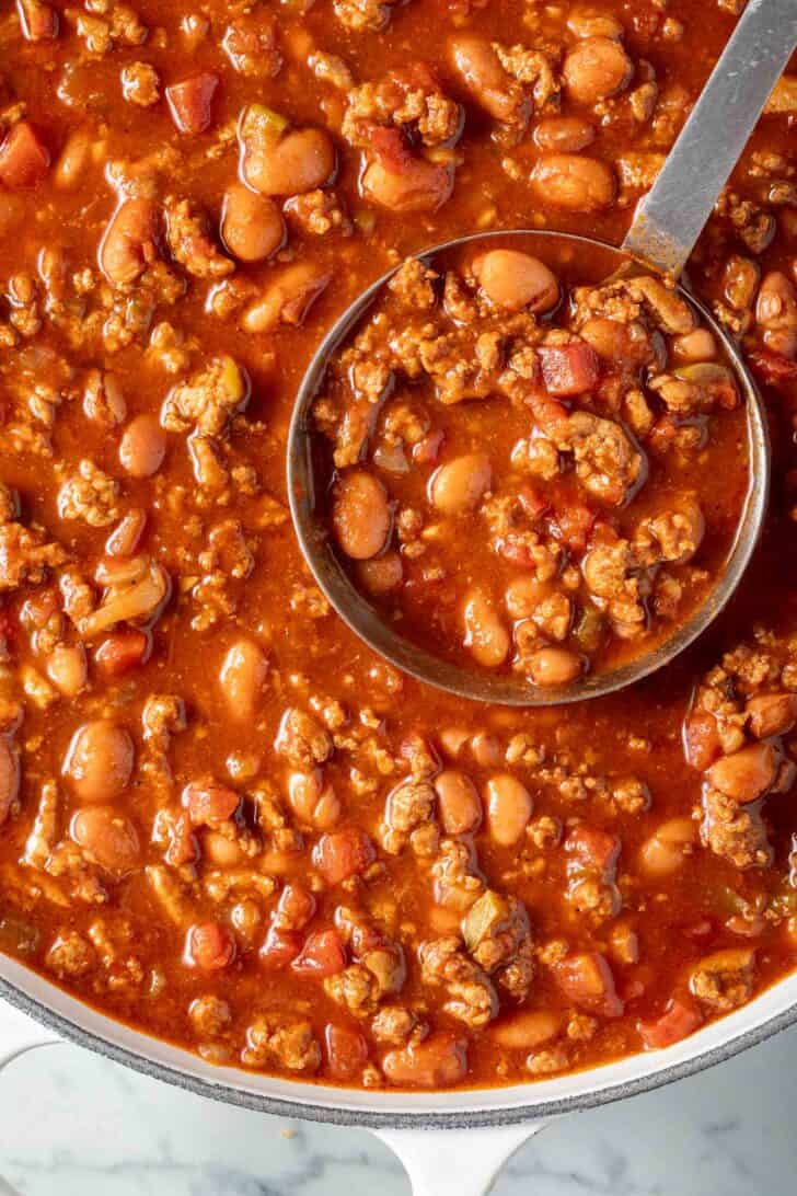 Ground Turkey Chili in a white pot with a ladle.