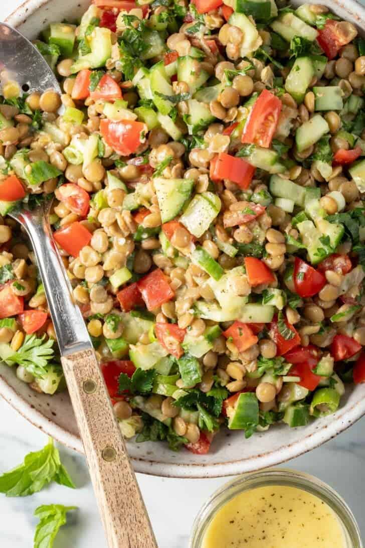 Lentil Tabbouleh in a white bowl with a spoon.