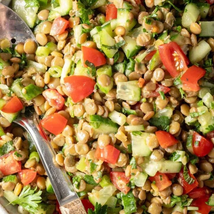Lentil Tabbouleh Salad in a white bowl with a spoon.