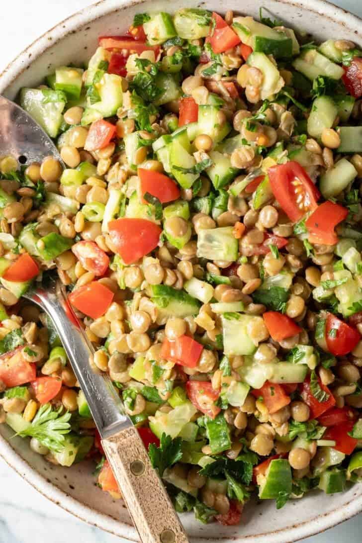 Lentil Tabbouleh Salad in a white bowl with a spoon.