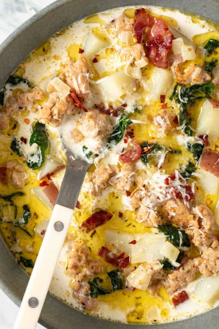 Zuppa Toscana Recipe Zuppa Toscana Soup in a gray bowl with a spoon.